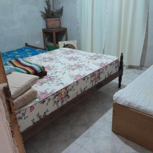 uma cama num quarto com uma colcha floral em Posada familiar em Belén