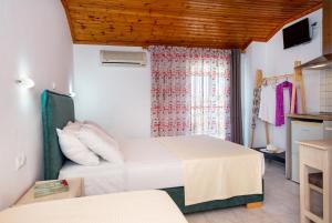 a small room with two beds and a tv at Kalogeraki Studios in Potos