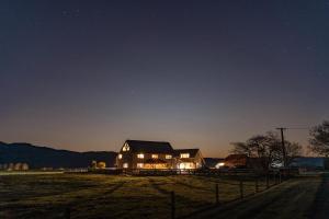 a large house in a field at night at housewithnonails in Matamata