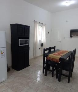 Una cocina con mesa y sillas y un microondas. en Casa en Chilecito La Cañada, en Chilecito