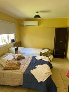 - une chambre avec un lit et des oreillers dans l'établissement Departamentos Crisol, à San Fernando del Valle de Catamarca