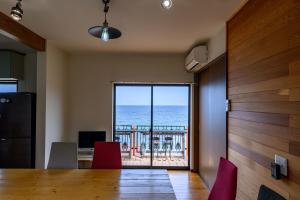 ein Esszimmer mit einem Tisch und Meerblick in der Unterkunft taiza house in Kyōtango