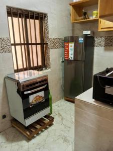 uma cozinha com um fogão e um frigorífico em Résidencesdavelsa em Cotonou