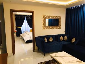 ein Wohnzimmer mit einem blauen Sofa und einem Spiegel in der Unterkunft 2 bhk apartment available in Al qasmiyah Sharjah in Schardscha