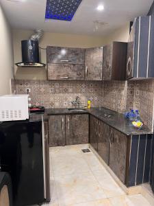 a kitchen with wooden cabinets and a counter top at 2 bhk apartment available in Al qasmiyah Sharjah in Sharjah