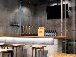 a bar with wooden tables and bottles of wine at Racine Home Kyoto SELF CHECK-IN in Kyoto