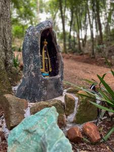 una roccia con un piccolo santuario in un giardino di Bosque Shalom a Frederico Westphalen