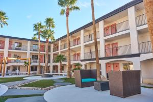 an exterior view of a building with palm trees at Aqua Soleil Hotel and Mineral Water Spa in Desert Hot Springs