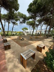 a park with benches and a playground with trees at Appartments VIP Al Hoceima Sfiha in Al Hoceïma