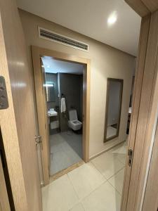 a bathroom with a toilet and a sink and a mirror at Appartments VIP Al Hoceima Sfiha in Al Hoceïma