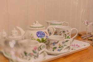 a tray of tea cups and saucers on a table at Villa City Break for couples 27 mins CHC Airport in Christchurch +23 photos