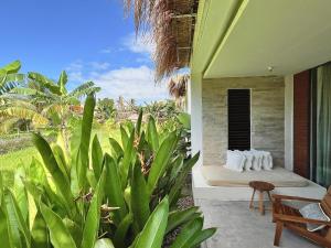 una habitación con cama y algunas plantas en Origin Lombok en Kuta Lombok