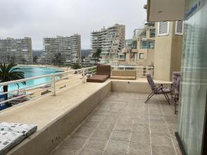 balcón con vistas a la piscina y a los edificios en San Alfonso del Mar, Algarrobo, en Algarrobo