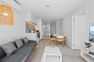 sala de estar con sofá y mesa en Bright CBD Apartment 2-Minutes To Gardens & Market, en Melbourne