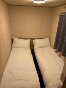 two beds in the corner of a small room at H13 Sunnymede in Ingoldmells