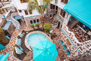 - une vue sur la piscine dotée de parasols bleus dans l'établissement Maidith Galapagos Inn, à Puerto Ayora