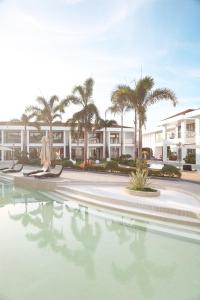 una piscina con palmeras frente a los apartamentos en condominio en Willander Resort, en Panglao