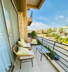 a balcony with chairs and tables on a balcony at Abdoun Place in Amman