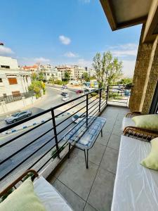 een balkon met 2 bedden en uitzicht op een straat bij Abdoun Place in Amman