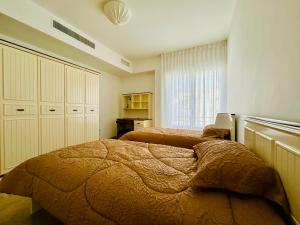 - une chambre avec 2 lits et une fenêtre dans l'établissement Abdoun Place, à Amman
