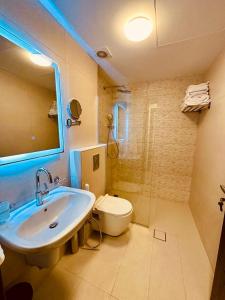 La salle de bains est pourvue d'un lavabo, de toilettes et d'un miroir. dans l'établissement Abdoun Place, à Amman