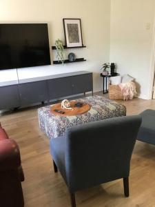 ein Wohnzimmer mit einem Tisch und einem TV in der Unterkunft Hyacinth Egan in Kalgoorlie