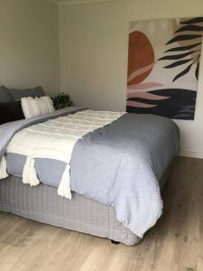 ein Schlafzimmer mit einem großen Bett mit weißer Bettwäsche in der Unterkunft Hyacinth Egan in Kalgoorlie