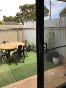 a patio with a table and chairs and a fence at Hyacinth Egan in Kalgoorlie