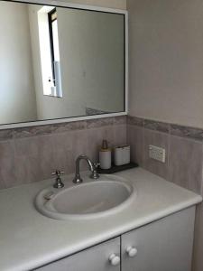 ein Badezimmer mit einem weißen Waschbecken und einem Spiegel in der Unterkunft Hyacinth Egan in Kalgoorlie