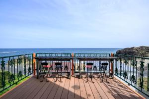 a deck with chairs and a view of the ocean at taiza house in Kyotango