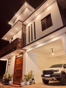 a white truck parked in front of a house at Tranquil Villa - Siargao in General Luna