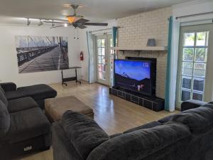 a living room with two couches and a flat screen tv at Executive Pool Home in Tampa