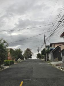 eine leere Straße mit Stromleitungen am Straßenrand in der Unterkunft Rohrmoser Geromax parque avion in San José