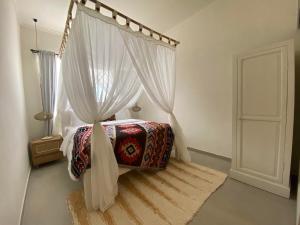 a bedroom with a canopy bed with white curtains at Villa EL NIS - LEGIAN - 4 Bedroom - 4 Bathroom - Luxury in Legian +28 photos