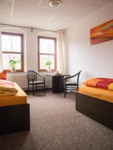 Cette chambre comprend deux lits, une table et des chaises. dans l'établissement Sefano Low Budget Hotel, à Nossen