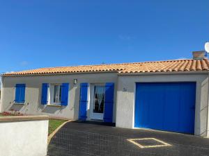 Maison Longeville-sur-Mer, 3 pièces, 5 personnes - FR-1-336-43 في لونجفيل-سور-مير: كراج بأبواب زرقاء على منزل