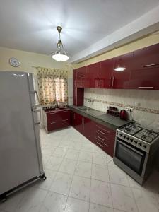 a kitchen with red cabinets and a stove top oven at Tranquility In the Center of Fez in Fez