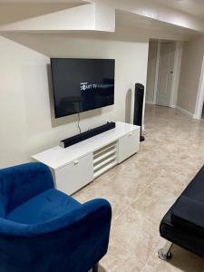 a living room with a flat screen tv and two chairs at Z & Z Apartment 2 in Newark