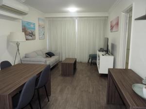 a living room with a couch and a table at Lovely 2 Bedroom Serviced Apartment & Free Parking in Mandurah
