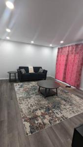 a living room with a couch and a table at Comfy one bedroom Airdrie in Airdrie