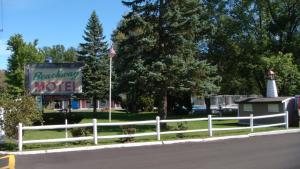 a sign for a motel with an american flag and a fence at Beachway Motel in Salisbury