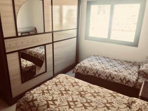 ein kleines Zimmer mit 2 Betten und einem Spiegel in der Unterkunft Um Uthaina Place in Amman