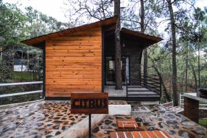 een kleine hut in het bos met een bord ervoor bij Cabaña Citrus para parejas in Mazamitla