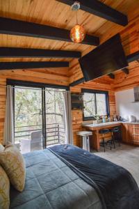 een slaapkamer met een bed en een bureau in een hut bij Cabaña Citrus para parejas in Mazamitla