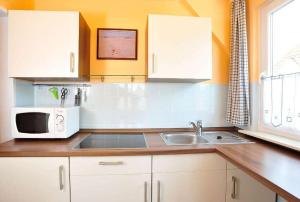 a kitchen with a sink and a microwave at Ferienwohnung-Min-Droom in Sankt Peter-Ording