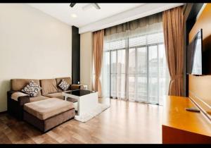 a living room with a couch and a large window at Cthomestay @ nova highland hotel in Brinchang