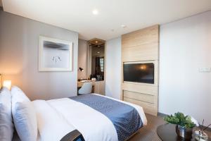 a bedroom with a large bed and a television at Centum Premier Hotel in Busan