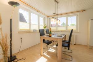 a dining room with a table and chairs and windows at Wohnung-A-303 in Böhl +5 photos