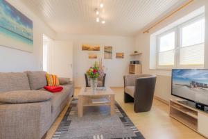a living room with a couch and a tv at Wohnung-A-303 in Böhl