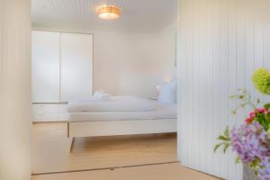 a bedroom with a bed with a mirror and flowers at Wohnung-A-303 in Böhl
